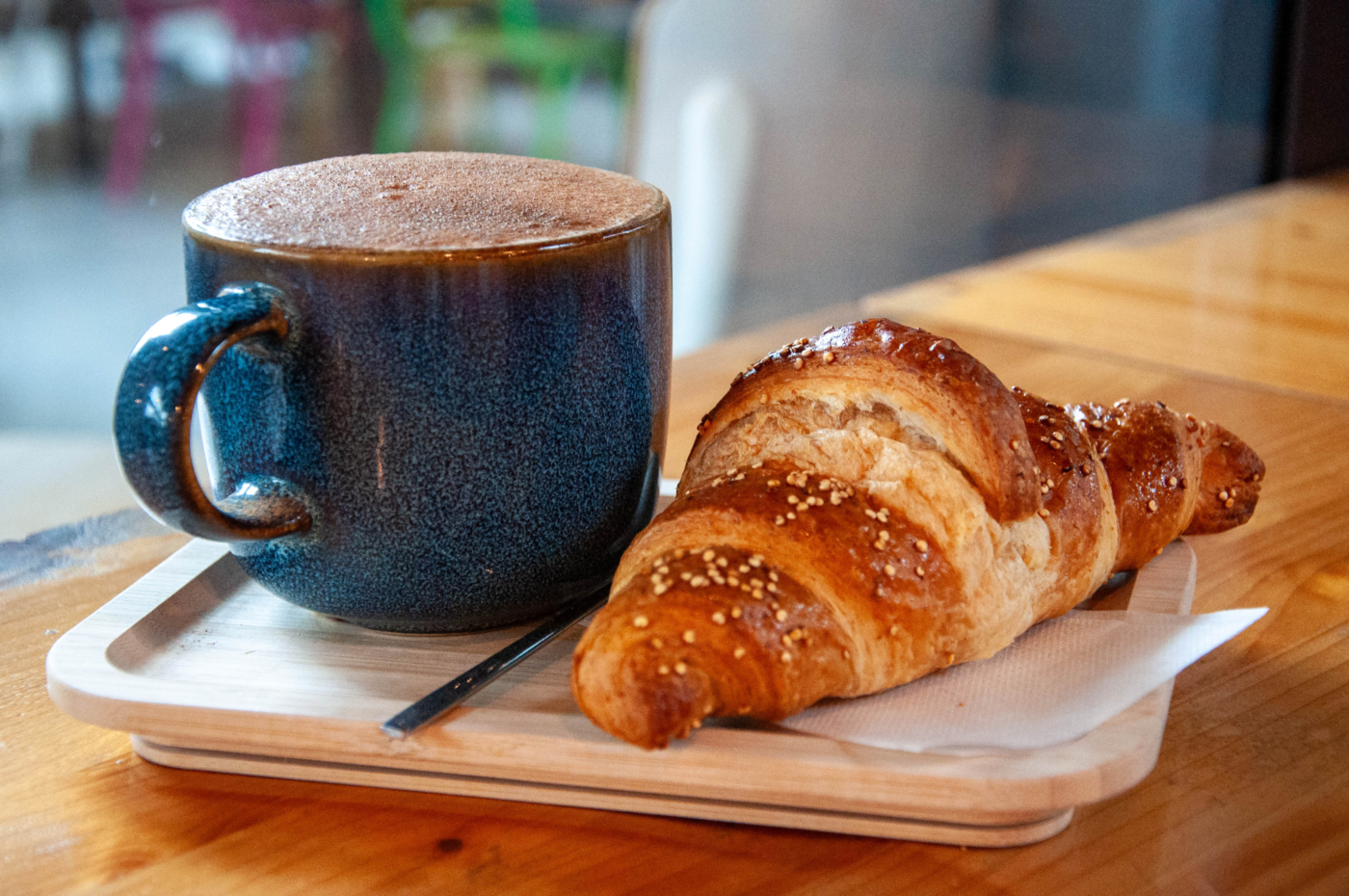 Tazza di cappuccino e Brioche poggiate su vassoio a climbing district