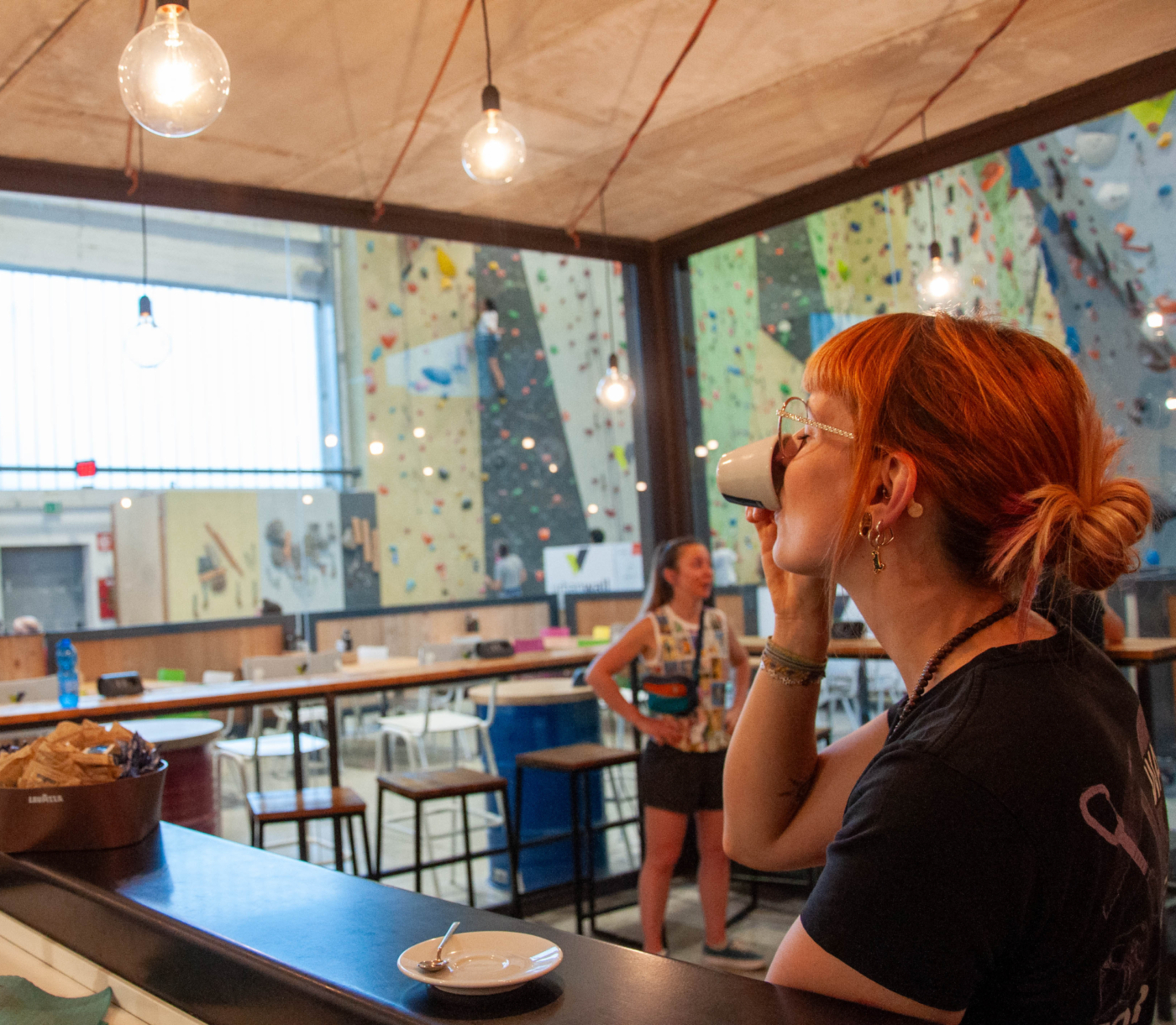 Barista beve caffè davanti a vetrate in Urbanwall Milano