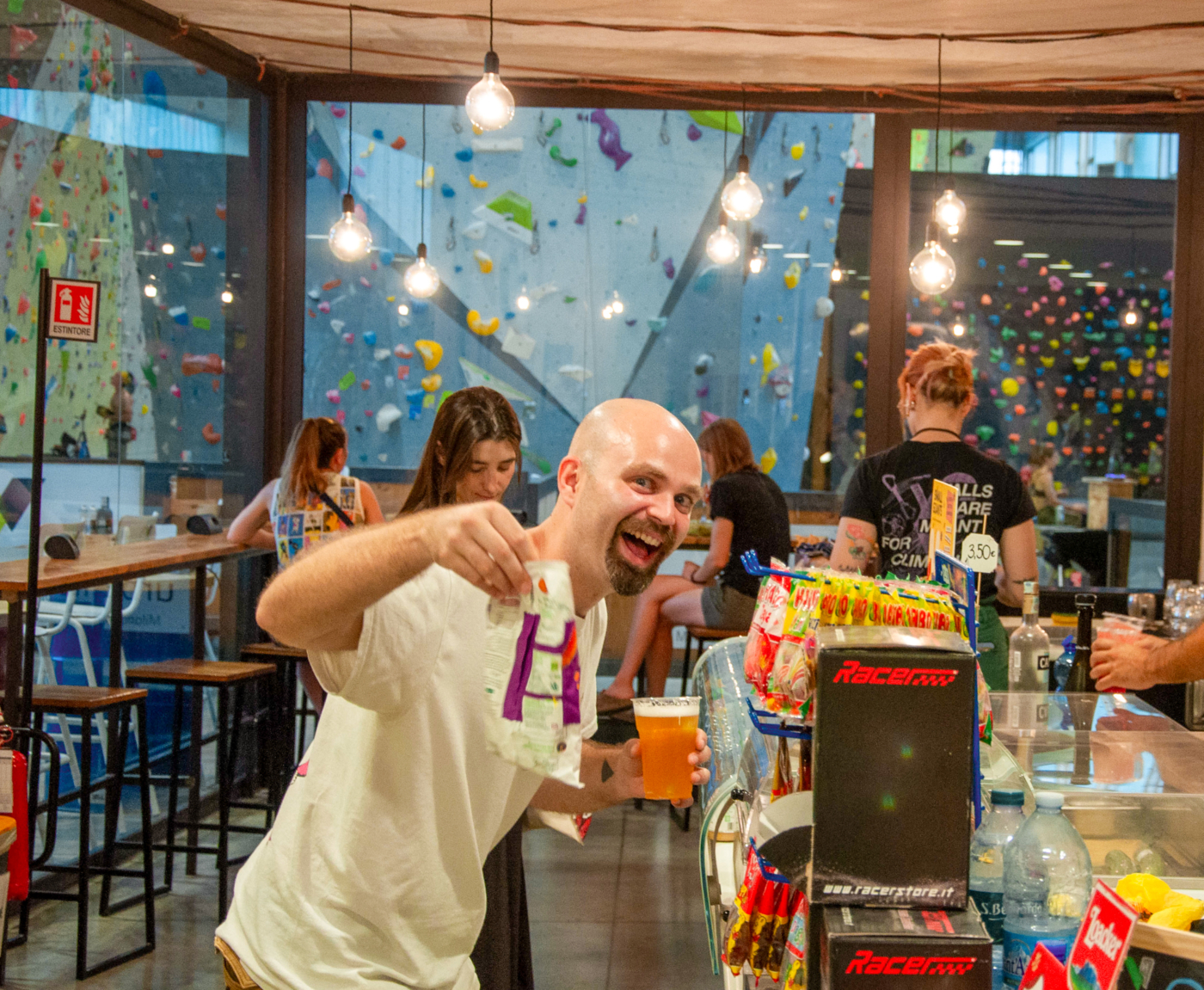 cliente felice nel bar di Urbanwall che ha in mano uno snack e un drink